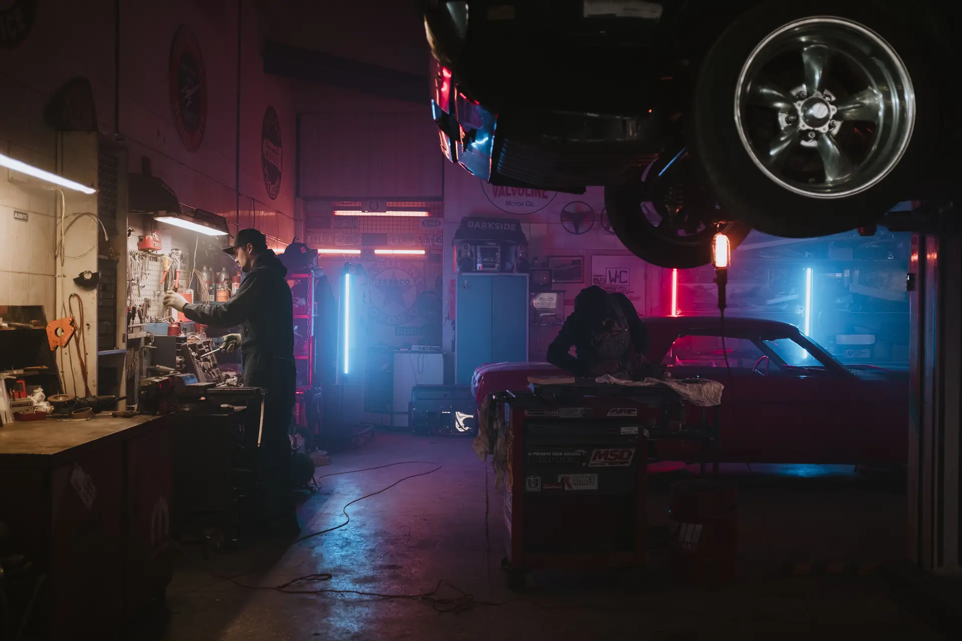 Mechanics working on car engine in workshop