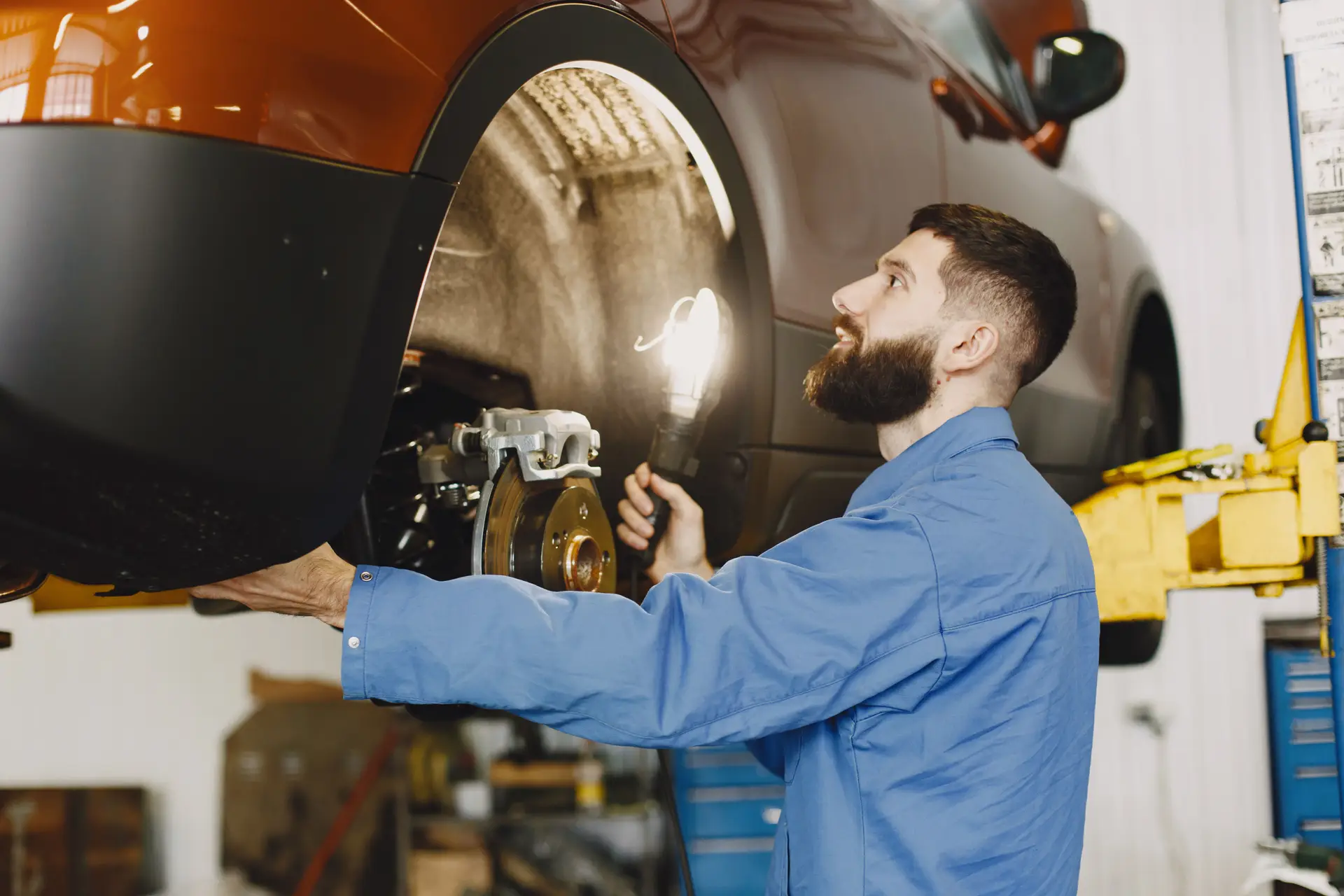 Mechanic inspecting car brakes
